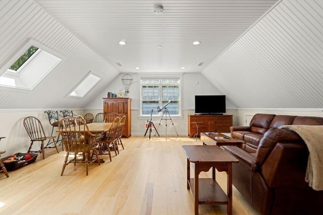 interior space featuring vaulted ceiling with skylight, wood finished floors, and recessed lighting