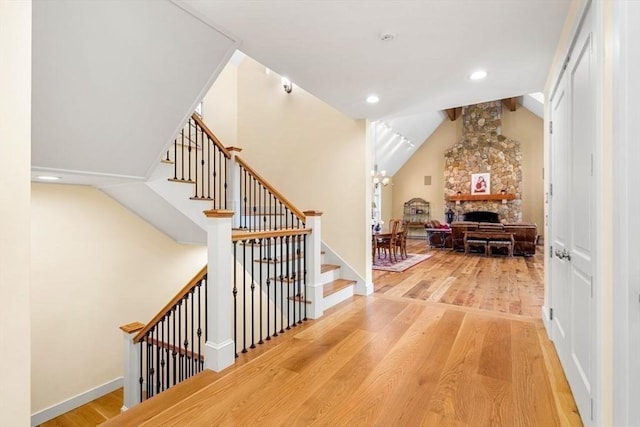 interior space featuring baseboards, a fireplace, wood finished floors, recessed lighting, and lofted ceiling