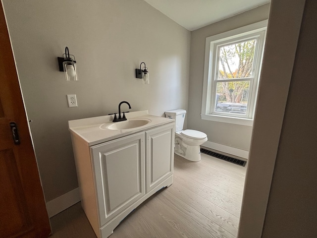 bathroom with vanity, toilet, and wood-type flooring