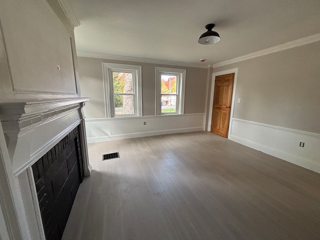 unfurnished living room featuring ornamental molding and hardwood / wood-style flooring