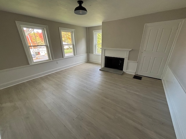 unfurnished living room featuring light hardwood / wood-style flooring and a healthy amount of sunlight