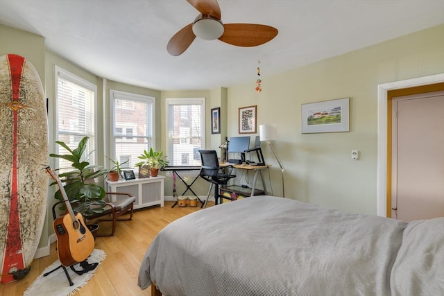 bedroom featuring radiator, ceiling fan, and light wood-type flooring