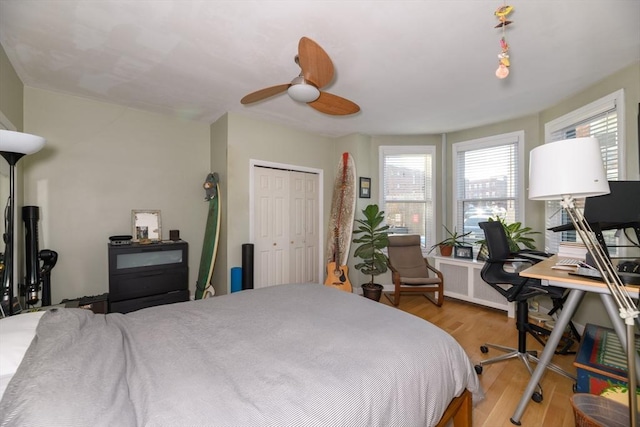 bedroom with radiator, ceiling fan, a closet, and light hardwood / wood-style flooring