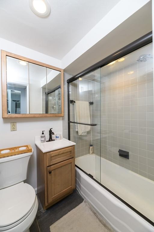 full bathroom with tile patterned floors, vanity, toilet, and shower / bath combination with glass door