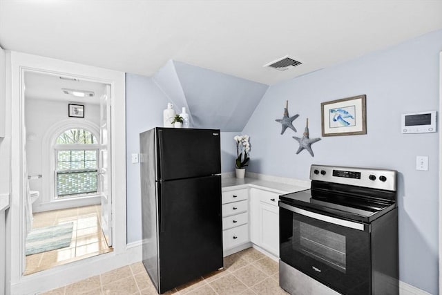kitchen featuring visible vents, freestanding refrigerator, light countertops, white cabinets, and stainless steel electric stove