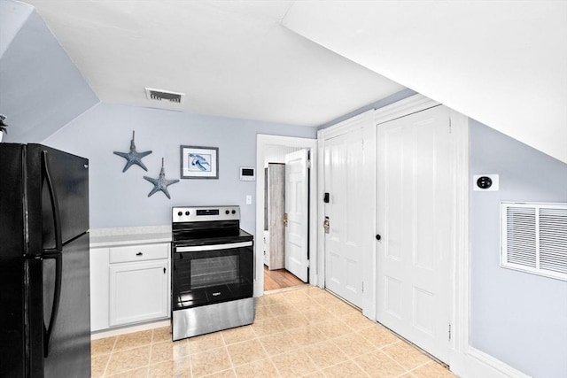 kitchen with freestanding refrigerator, electric range, white cabinets, and visible vents