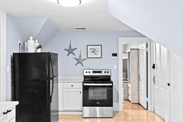 kitchen with visible vents, light countertops, white cabinets, freestanding refrigerator, and stainless steel electric stove