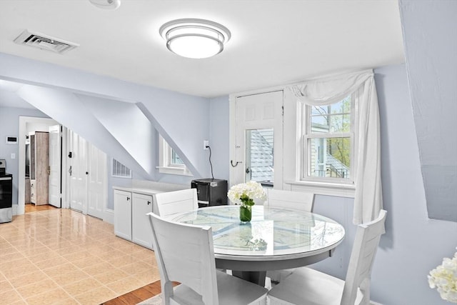 dining space with baseboards, visible vents, and stairway