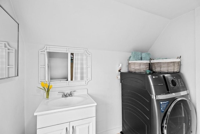 washroom featuring washer / dryer, cabinet space, and a sink