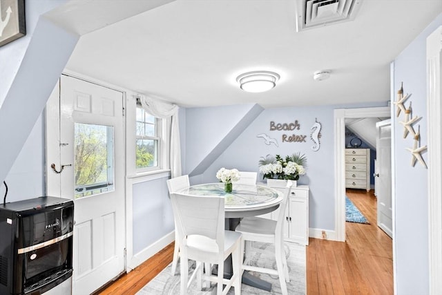 dining area featuring visible vents, light wood finished floors, and baseboards