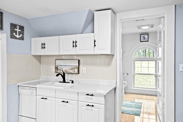 kitchen featuring light countertops, white cabinetry, a sink, and dishwasher