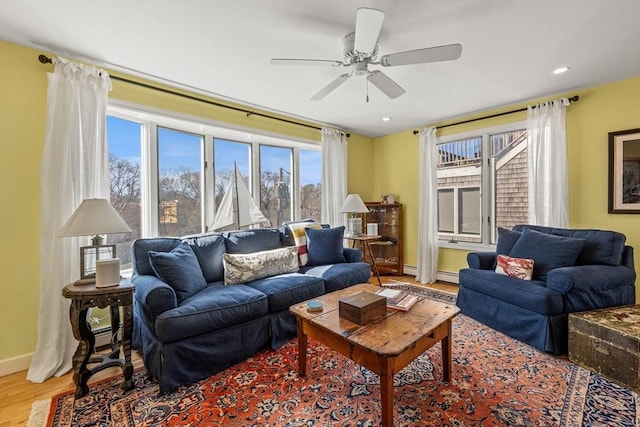 living room featuring ceiling fan, a baseboard radiator, recessed lighting, baseboards, and light wood finished floors