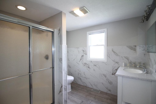 23 Walnut St, Ludlow, MA 01056 - full bath featuring tile walls, vanity, a stall shower, wood finished floors, and a wainscoted wall