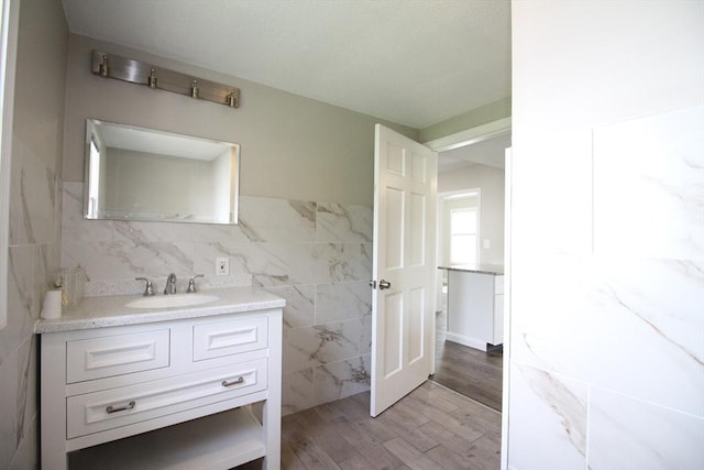 23 Walnut St, Ludlow, MA 01056 - bathroom with tile walls, vanity, and wood finished floors