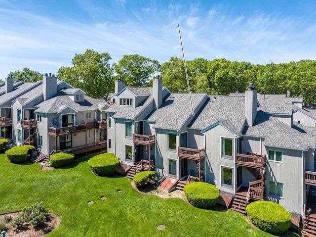17 Ships Way Unit 17, Bourne, MA 02532 - back of house with a residential view, a chimney, roof with shingles, and a lawn