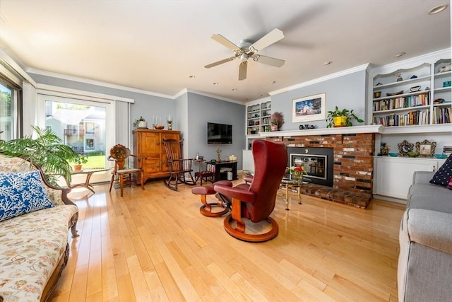 17 Ships Way Unit 17, Bourne, MA 02532 - living room with light wood-type flooring, built in shelves, ceiling fan, a brick fireplace, and ornamental molding