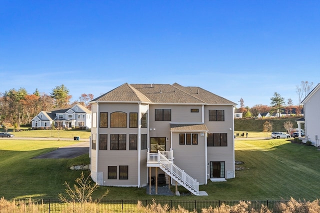 rear view of house featuring a lawn and a wooden deck