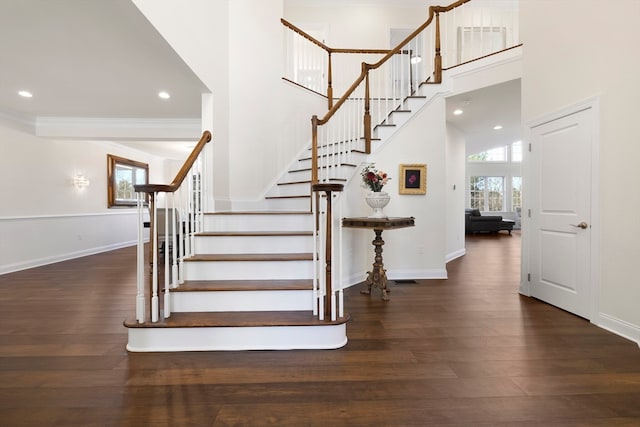 staircase featuring hardwood / wood-style floors and a high ceiling