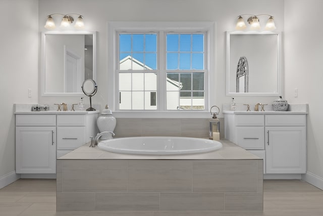 bathroom featuring vanity and a relaxing tiled tub