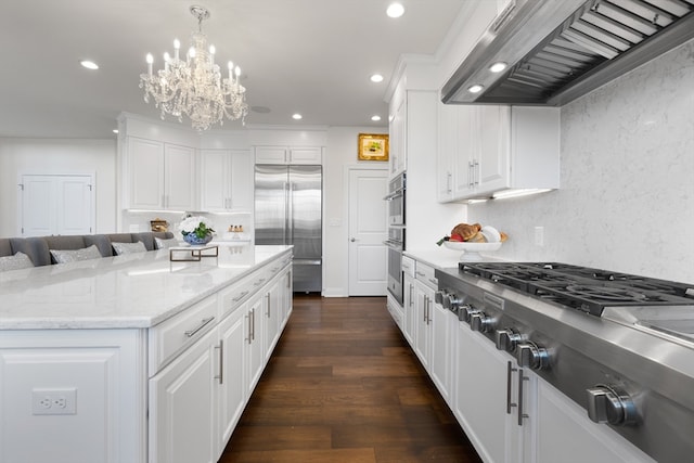 kitchen featuring dark wood-type flooring, stainless steel appliances, decorative light fixtures, white cabinets, and custom exhaust hood