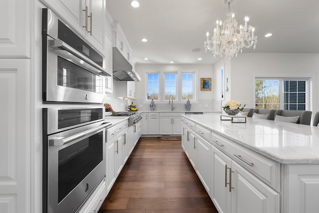 kitchen featuring white cabinets, dark hardwood / wood-style floors, a center island, and appliances with stainless steel finishes