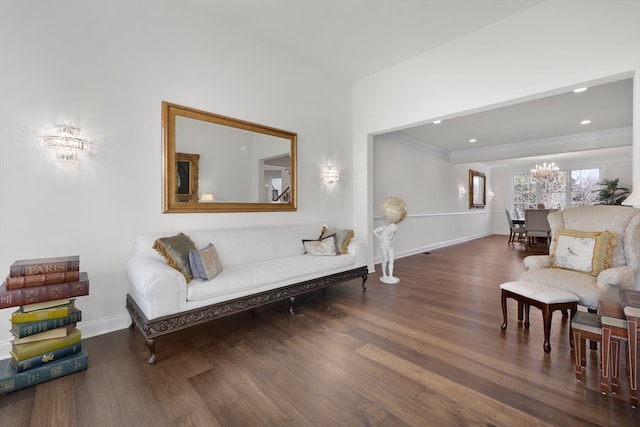 sitting room with a chandelier, dark hardwood / wood-style floors, and ornamental molding