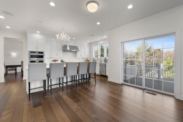 kitchen featuring white cabinets, dark hardwood / wood-style floors, a kitchen island, and appliances with stainless steel finishes