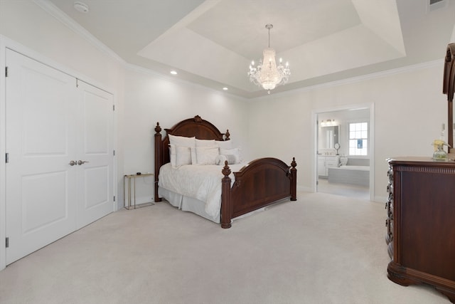 carpeted bedroom with a tray ceiling, ensuite bath, and crown molding