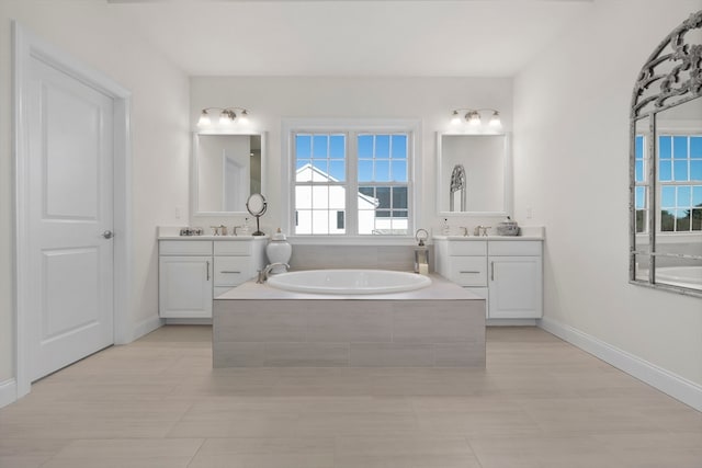 bathroom featuring vanity and tiled tub