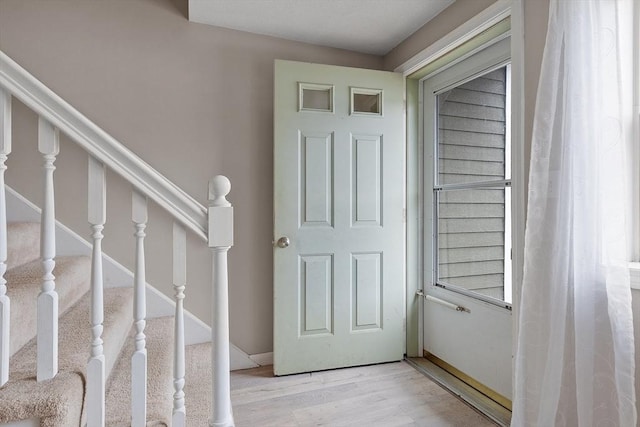 staircase featuring baseboards and wood finished floors