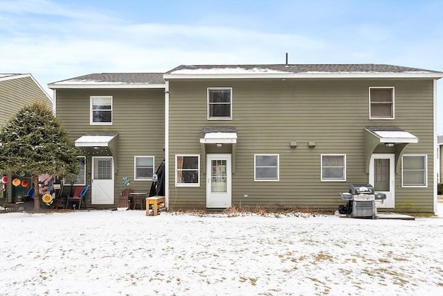 view of snow covered rear of property