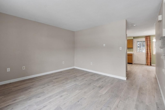 empty room with light wood finished floors and baseboards