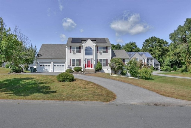 109 Macintosh Ln, Fitchburg, MA 01420 - colonial inspired home with solar panels, curved driveway, a front lawn, and an attached garage
