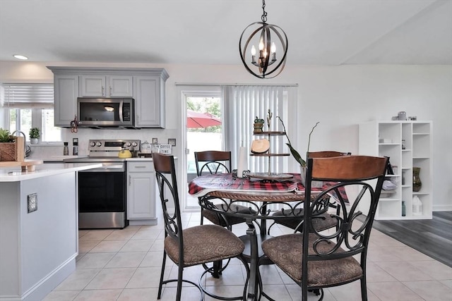 109 Macintosh Ln, Fitchburg, MA 01420 - dining area with light tile patterned floors, a chandelier, and a healthy amount of sunlight