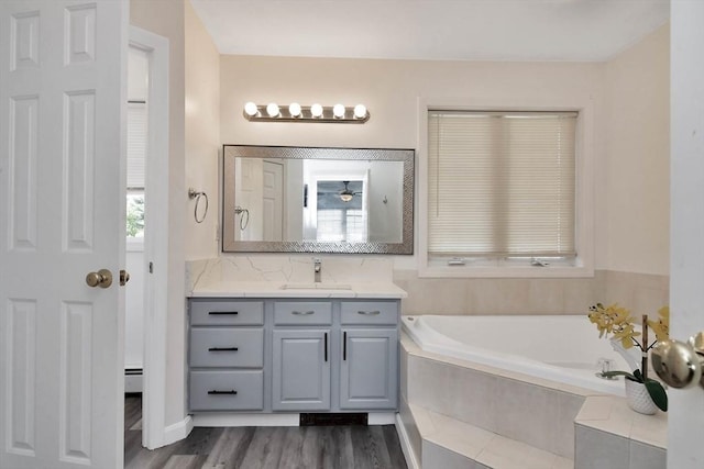 109 Macintosh Ln, Fitchburg, MA 01420 - bathroom with a garden tub, wood finished floors, vanity, and baseboard heating