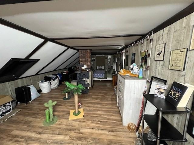 interior space with wood finished floors and vaulted ceiling