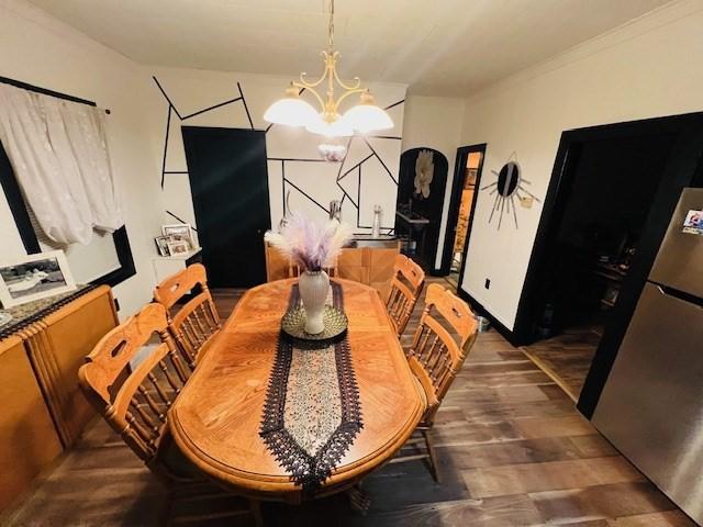 dining space with wood finished floors and a chandelier