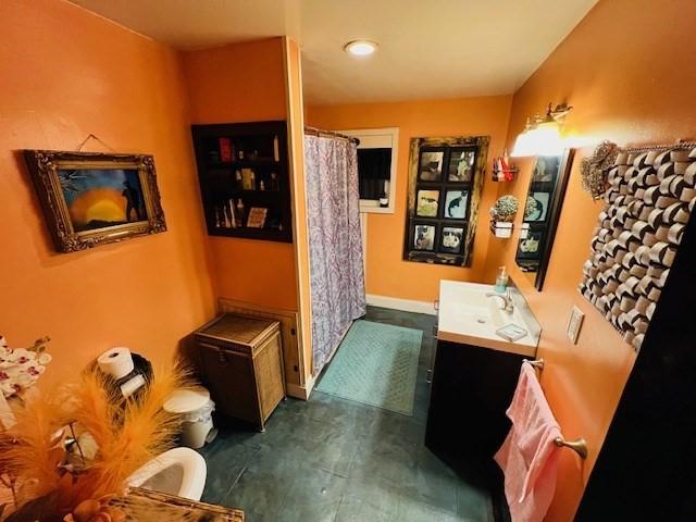 bathroom with vanity, a shower with shower curtain, and baseboards