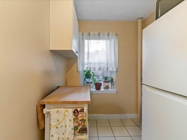 kitchen featuring white fridge and light tile patterned flooring