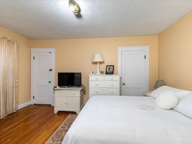 bedroom with a textured ceiling and hardwood / wood-style flooring