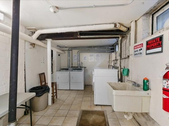 laundry room with independent washer and dryer, light tile patterned floors, and sink