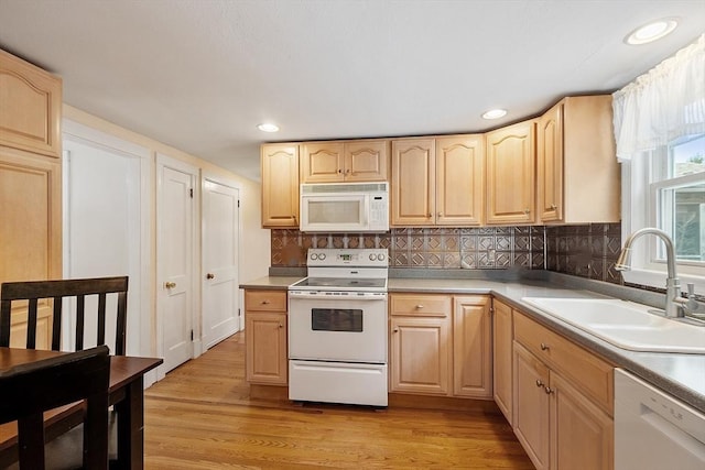 kitchen featuring sink, white appliances, light brown cabinetry, and light wood-type flooring