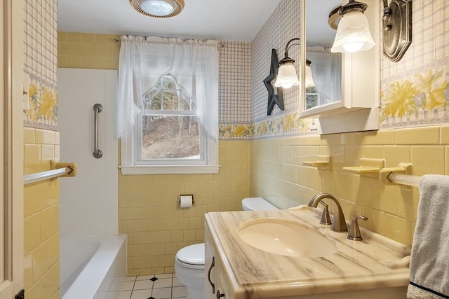 bathroom featuring vanity, toilet, tile walls, and tile patterned floors