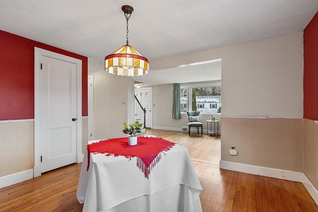 dining space with wood-type flooring and wood walls