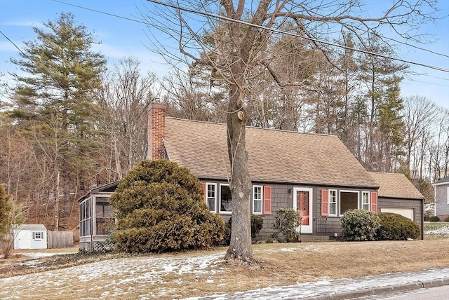 cape cod house featuring a garage and a sunroom