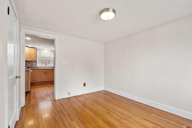 spare room with light wood-type flooring and sink