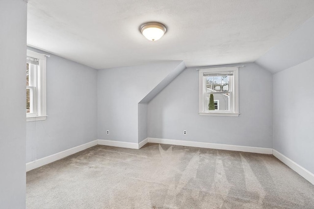 additional living space with carpet floors and vaulted ceiling