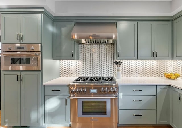 34 Walker St, Somerville, MA 02144 - kitchen featuring appliances with stainless steel finishes, green cabinets, exhaust hood, and light countertops