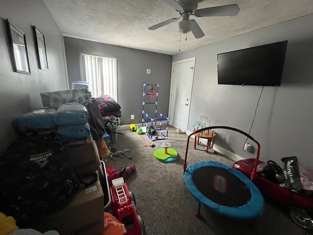 rec room with a textured ceiling, carpet, and ceiling fan