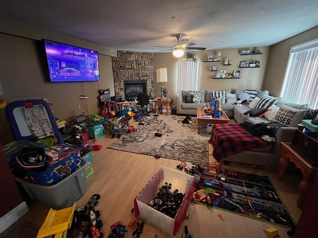 living room featuring hardwood / wood-style floors, ceiling fan, and a fireplace